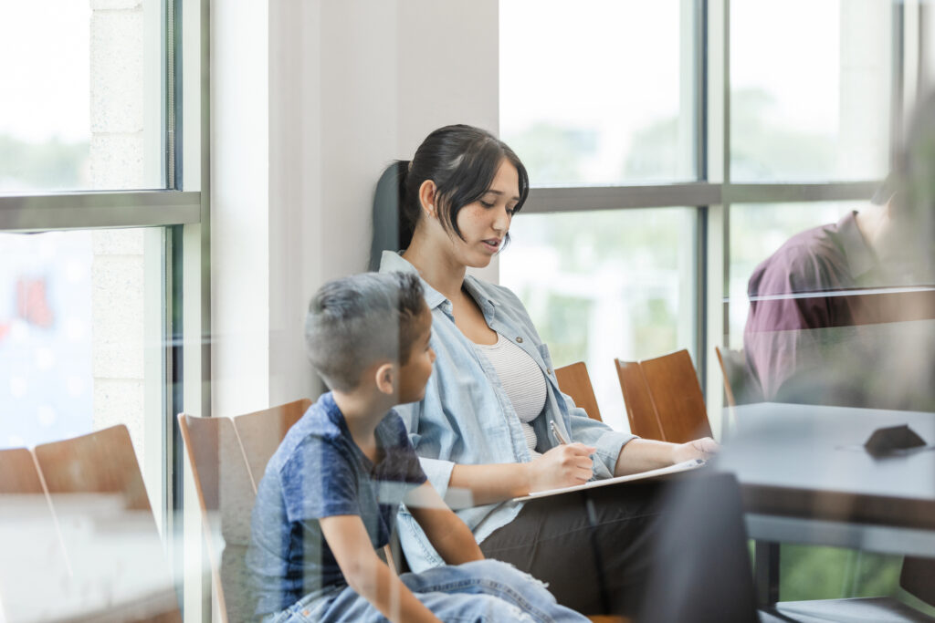 Young mother fills out forms for her son to be seen by the doctor